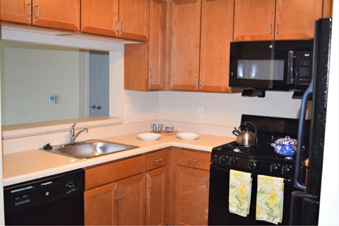 A kitchen with wooden cabinets and a black stove.