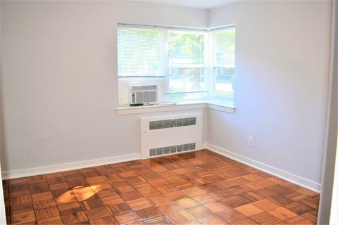 A room with a window and a radiator on the floor.