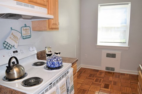 A kitchen with a white stove top and a blue and white kettle.