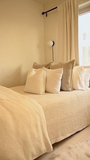 A bed with a white comforter and pillows.