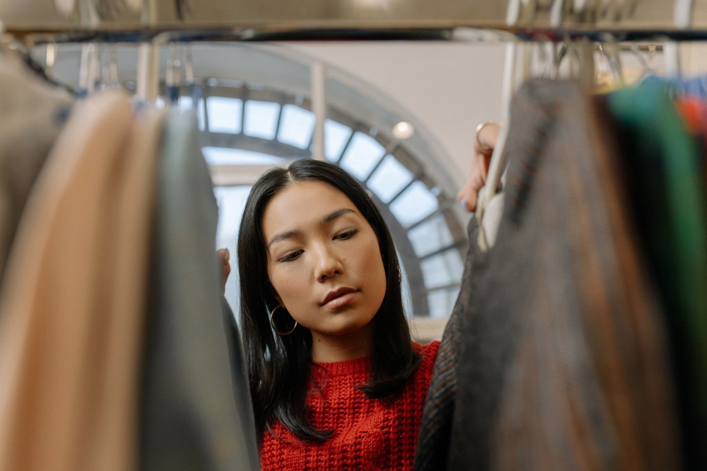 A woman is looking at clothes in a store.