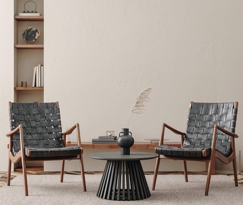 Two chairs and a table with a vase on it.