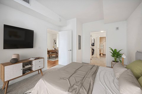 Bedroom with mounted television and ensuite bathroom at The Premier Apartments, Silver Spring