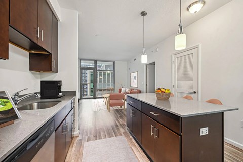 A kitchen with dark wood cabinets and a marble countertop.