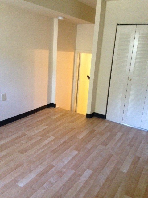 A room with a wooden floor and white walls.