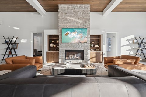 A modern living room with a fireplace and a painting above it.