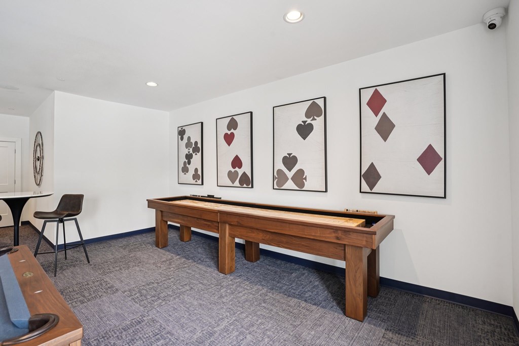 A room with a table, chairs and pictures on the wall.