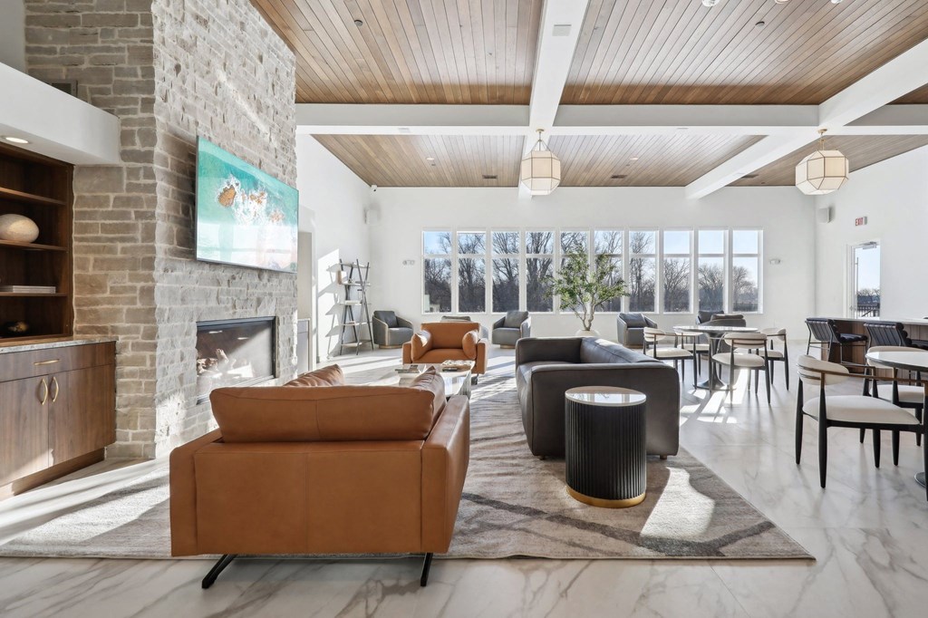 A living room with a stone fireplace and a painting of two people on the wall.