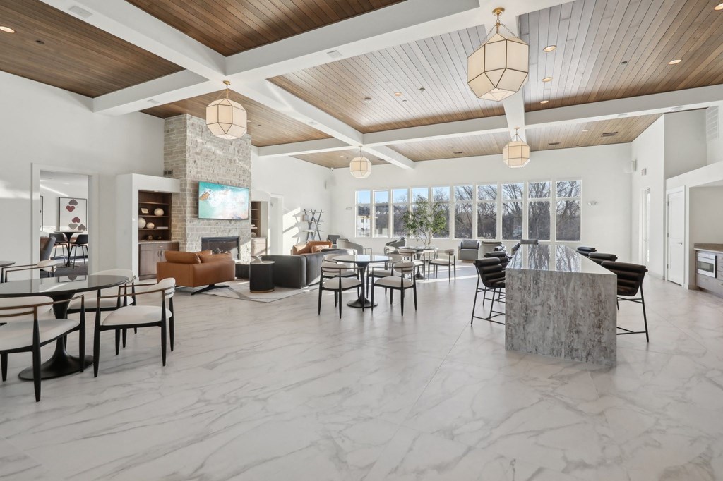 A spacious living room with a stone fireplace and a variety of seating options.