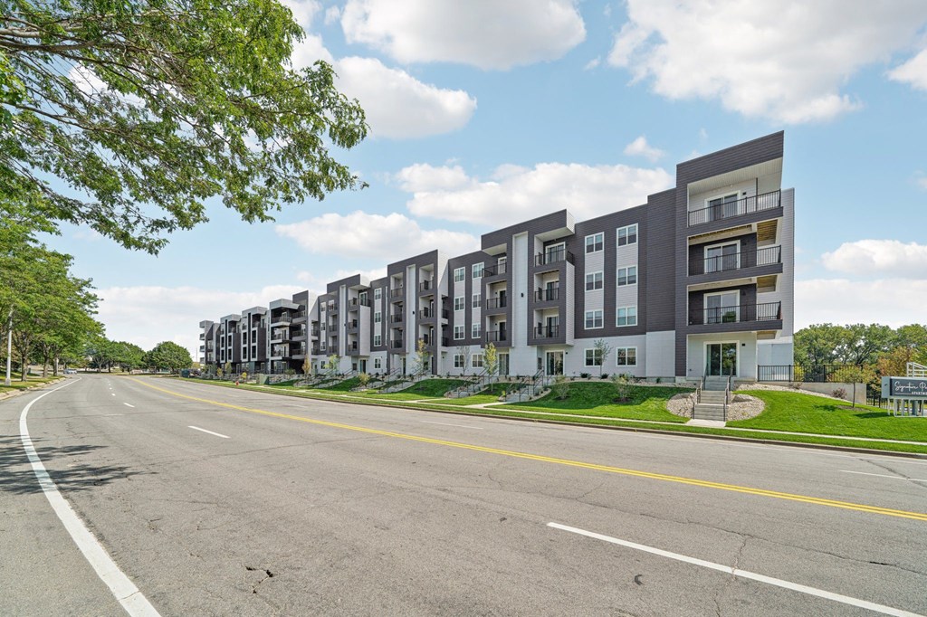 a row of apartment buildings on the side of a street