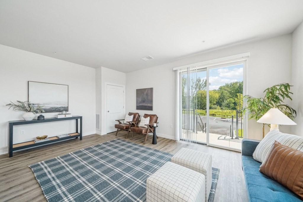 a living room with white walls and a sliding glass door to a patio