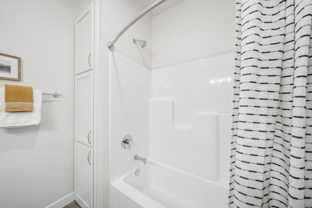 a white bathroom with a shower and a tub