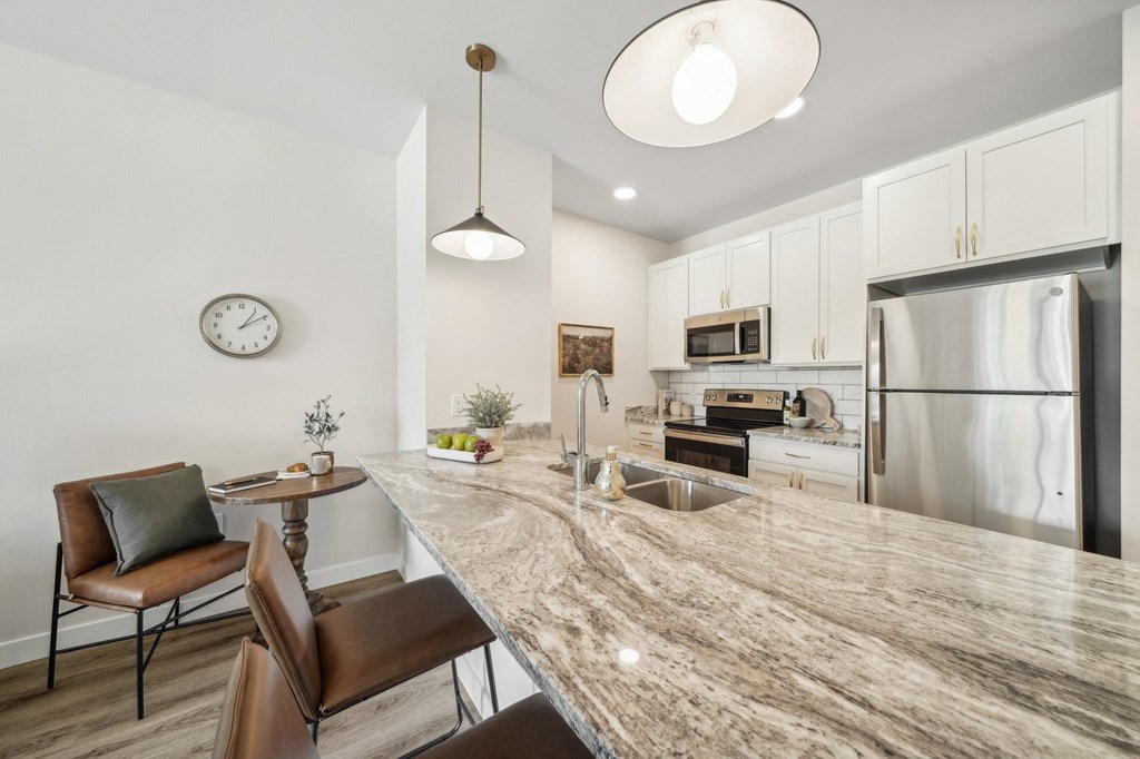 a kitchen with a large counter top and a stainless steel refrigerator