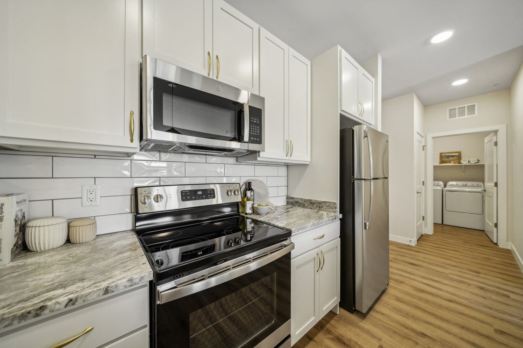 a kitchen with white cabinets and stainless steel appliances