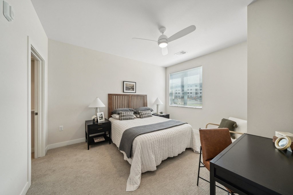 a bedroom with a large bed and a ceiling fan