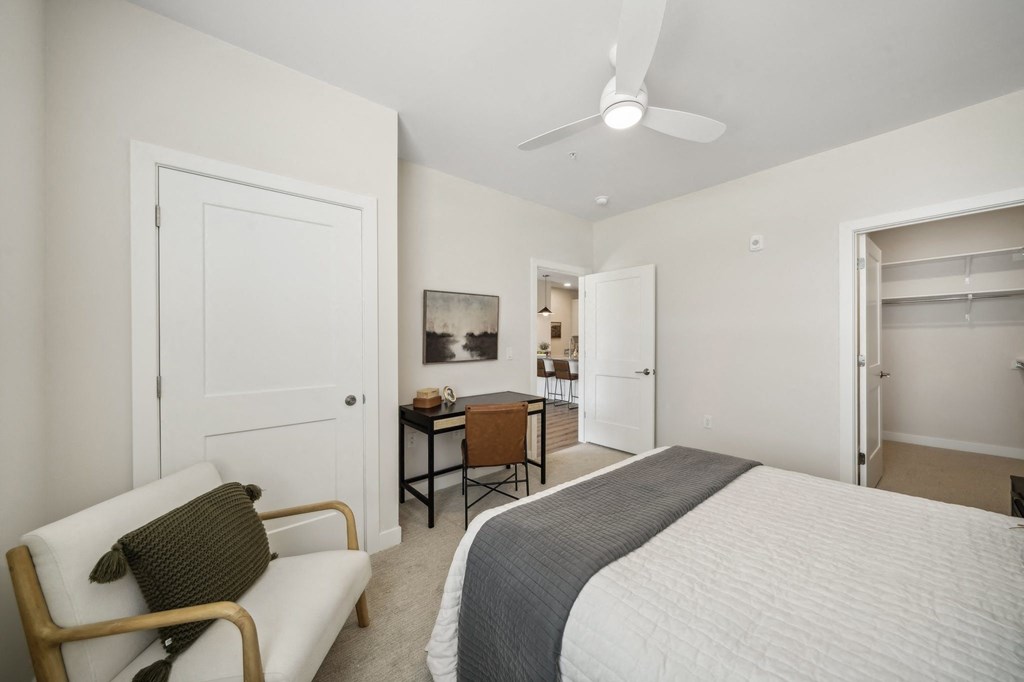 a bedroom with a large bed and a desk with a chair