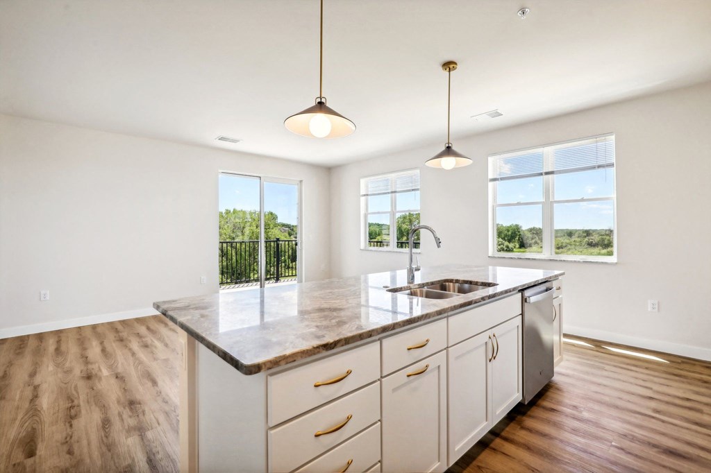 an empty kitchen with a sink and a counter top