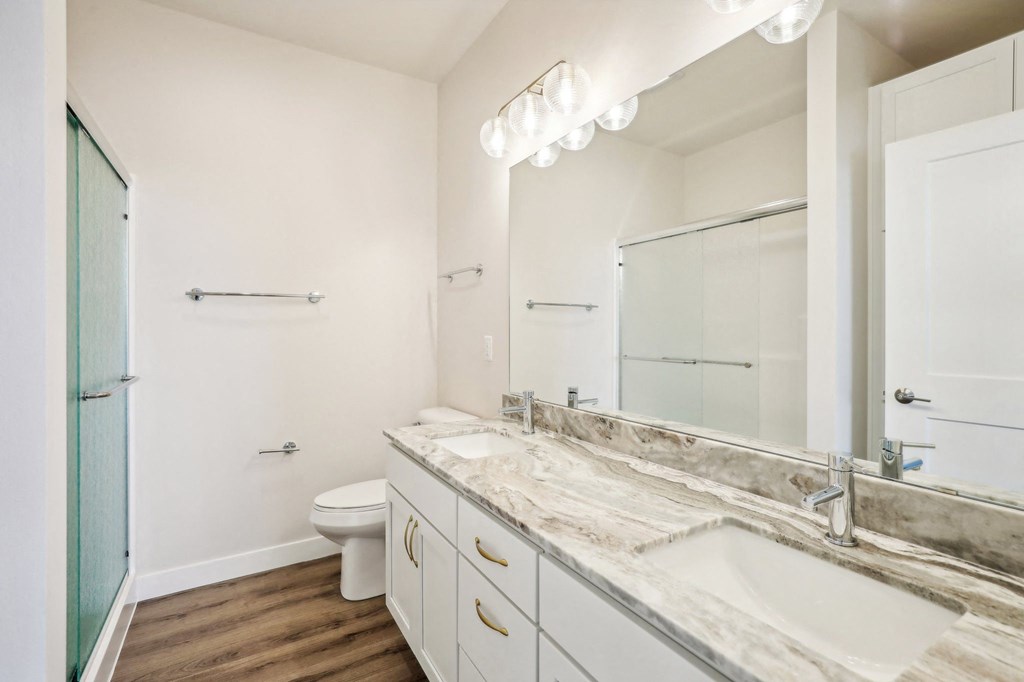 a bathroom with a large mirror and a toilet and a sink