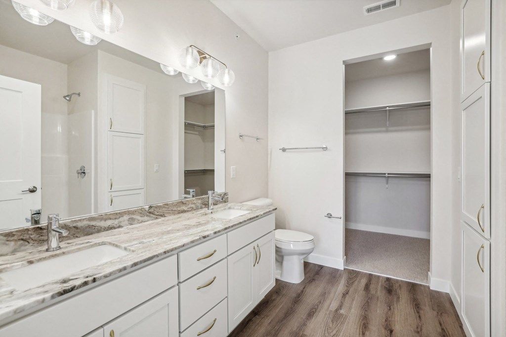 a bathroom with a large mirror and a toilet and a sink