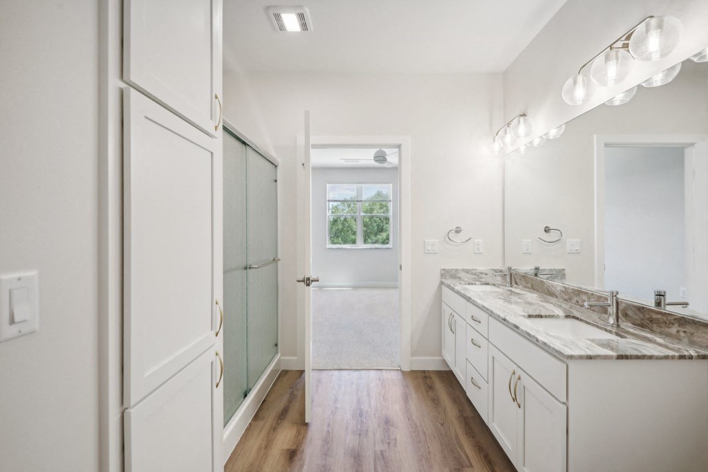 a bathroom with white cabinets and a sink and a mirror