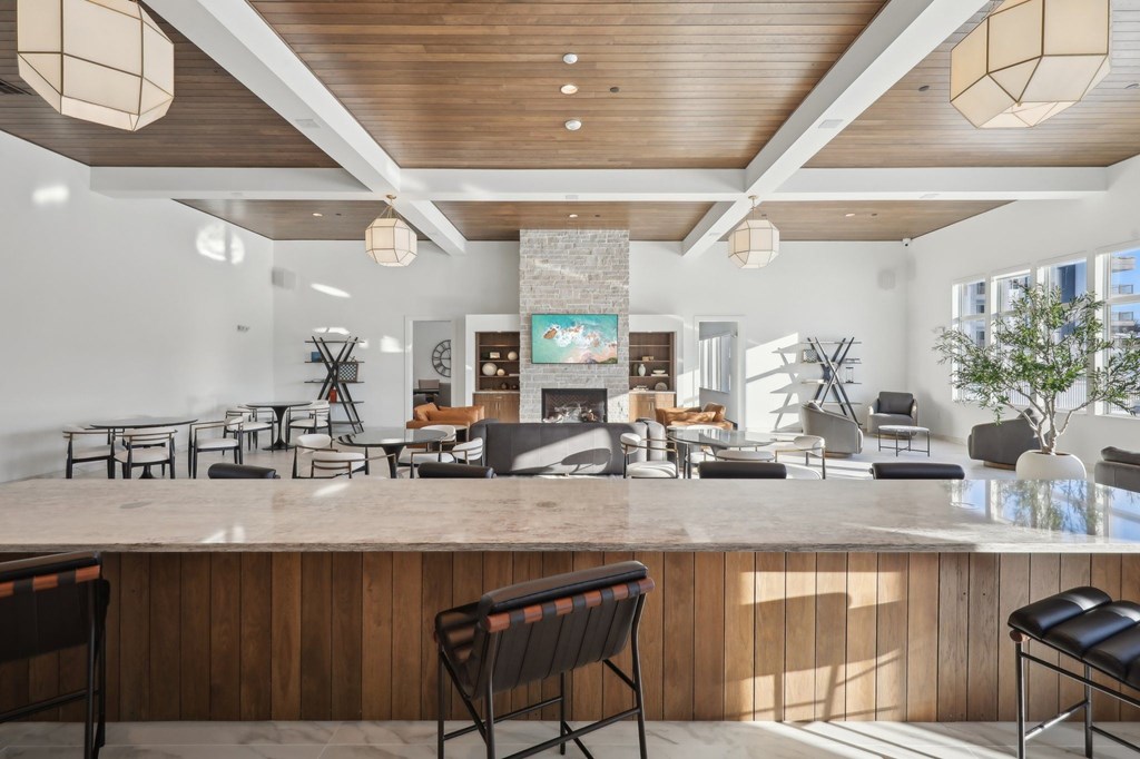 A modern living room with a wooden ceiling and a large TV mounted on the wall.