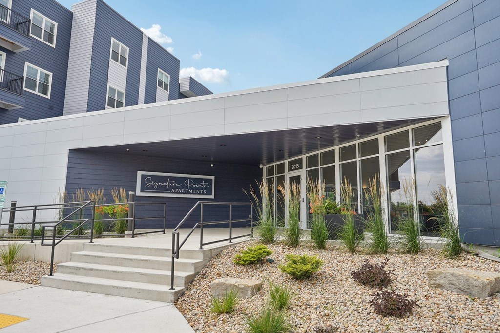 The front of a building with a sign that reads "Signature Pointe Apartments".
