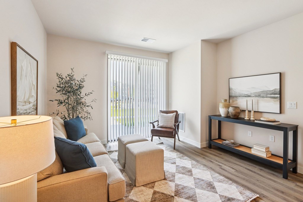 A living room with a couch, chair, and a table with a vase on it.