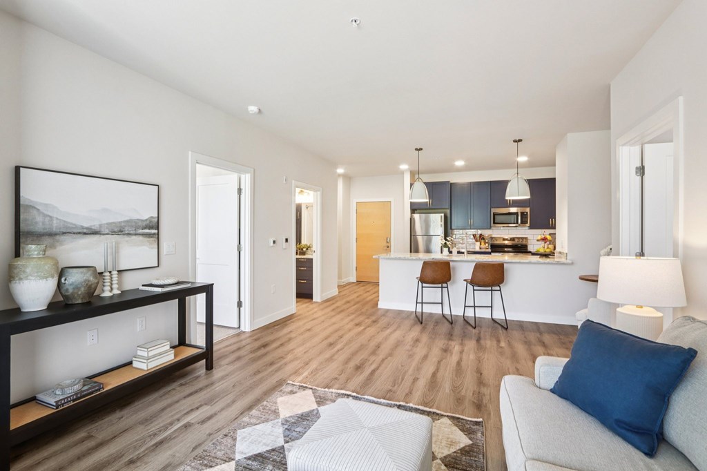 A modern living room with a white couch and a wooden floor.