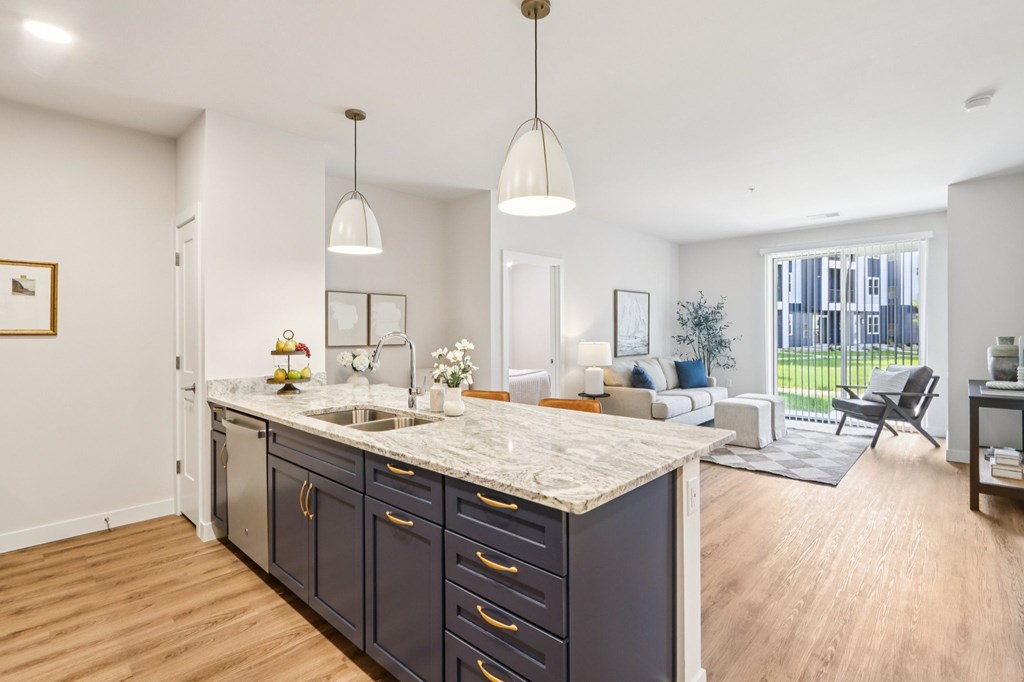 A kitchen with a marble countertop and dark wood cabinets.
