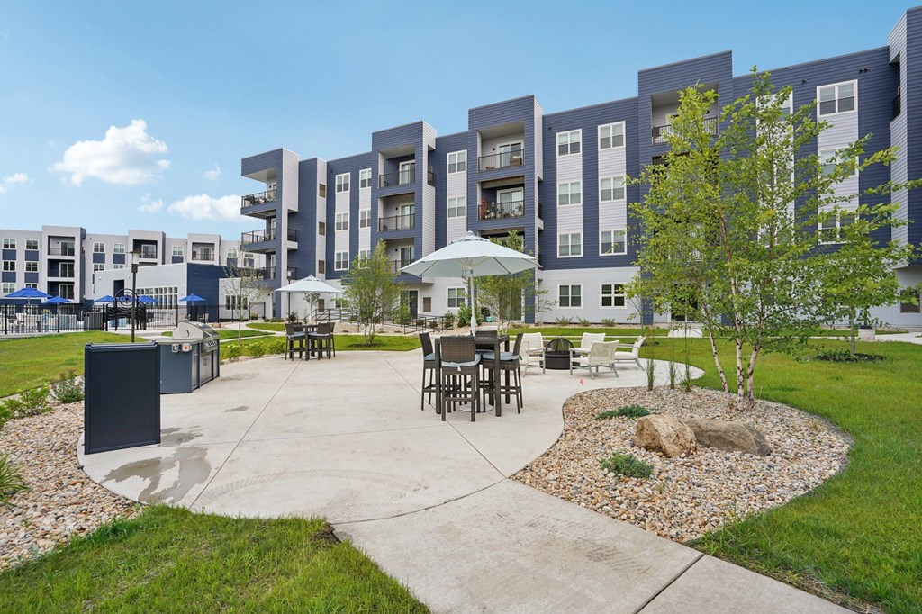 A modern apartment complex with a courtyard and seating area.