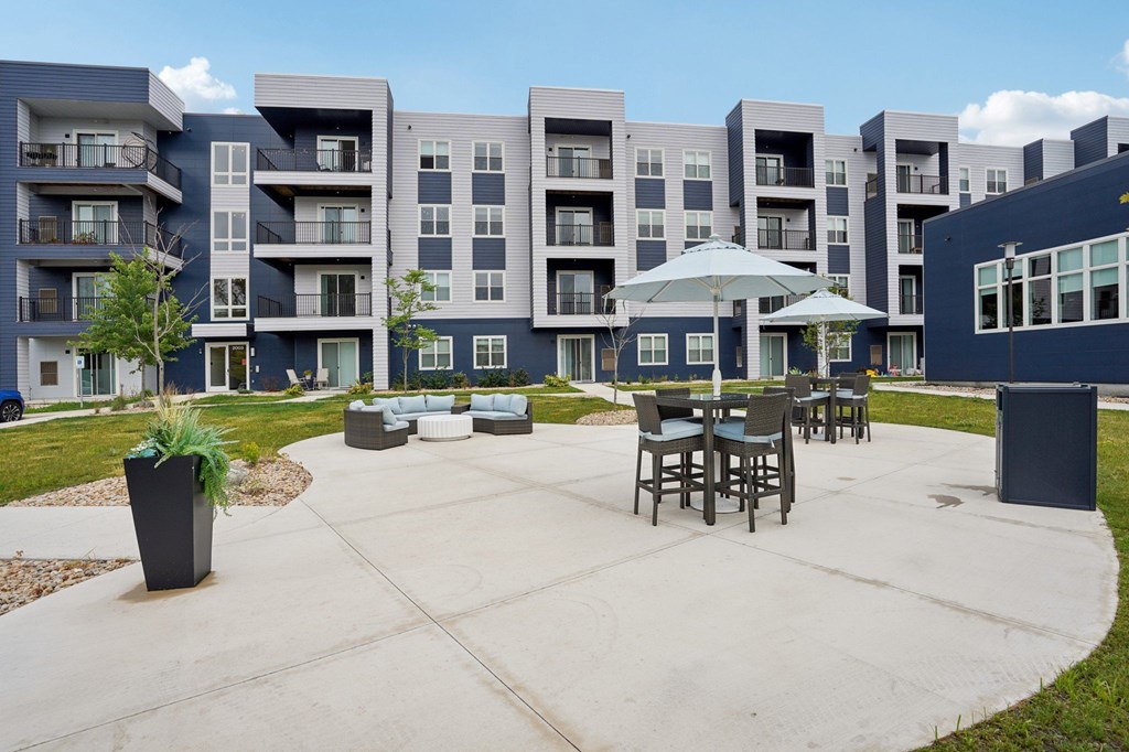 A large building with a patio and chairs in front.