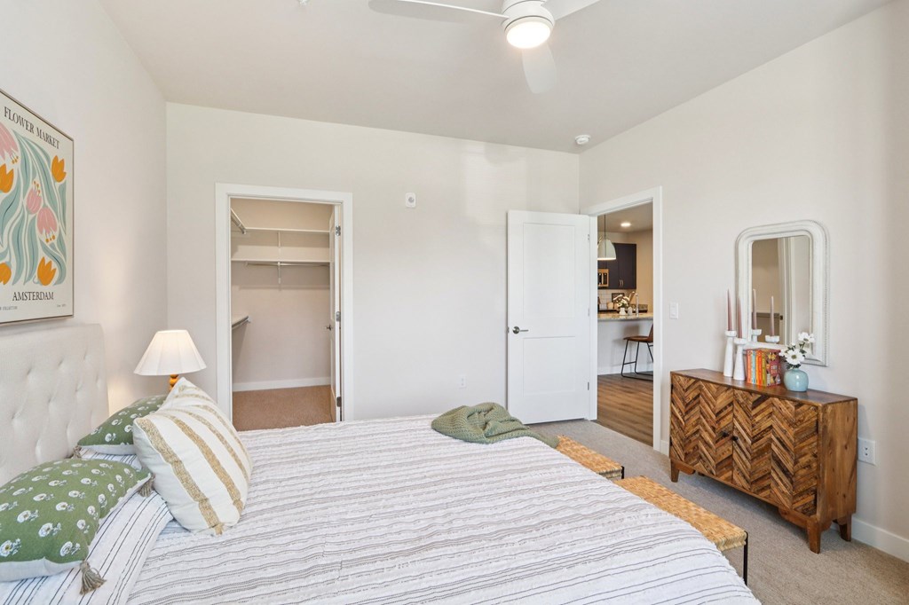 A bedroom with a bed, dresser, and mirror.