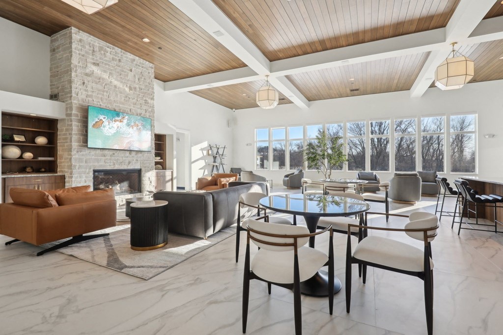 A modern living room with a stone fireplace and a large painting above it.