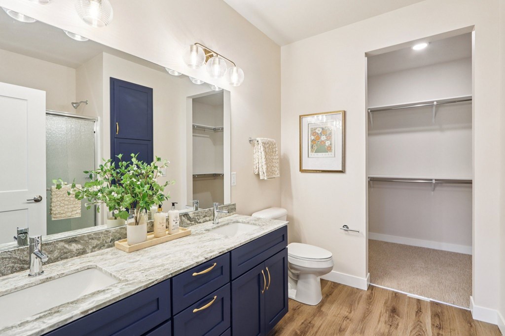 A bathroom with a white counter top and a white sink.
