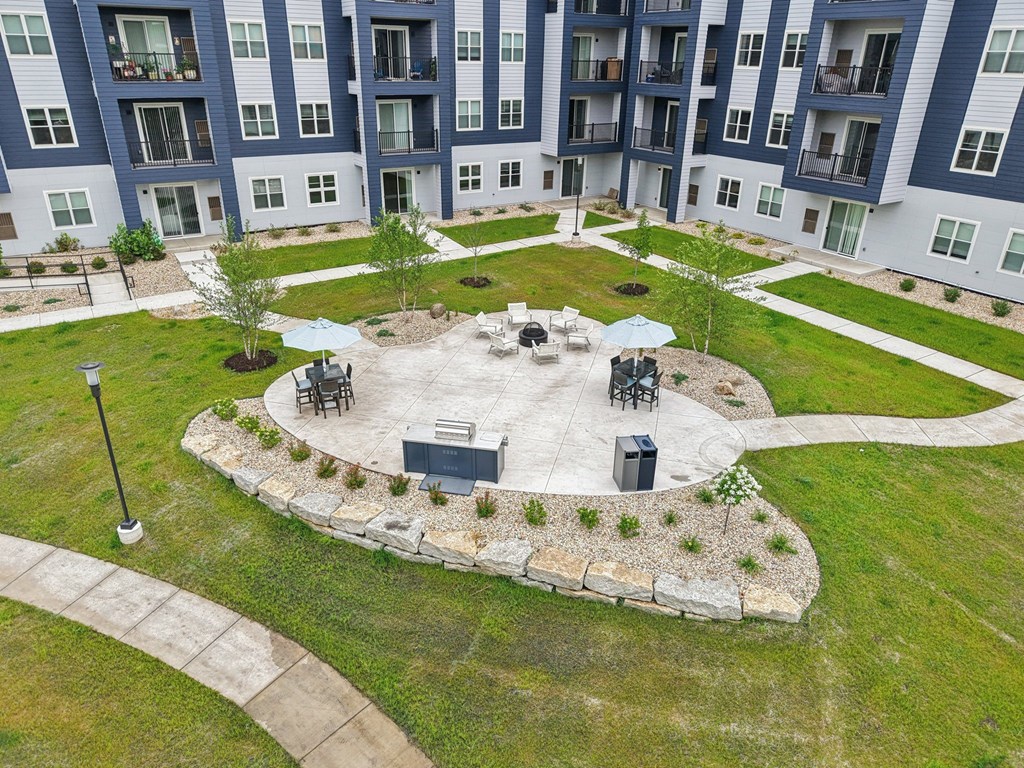 A courtyard with a fire pit and seating area surrounded by apartment buildings.