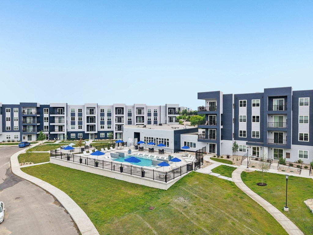 A large apartment complex with a pool in the middle.