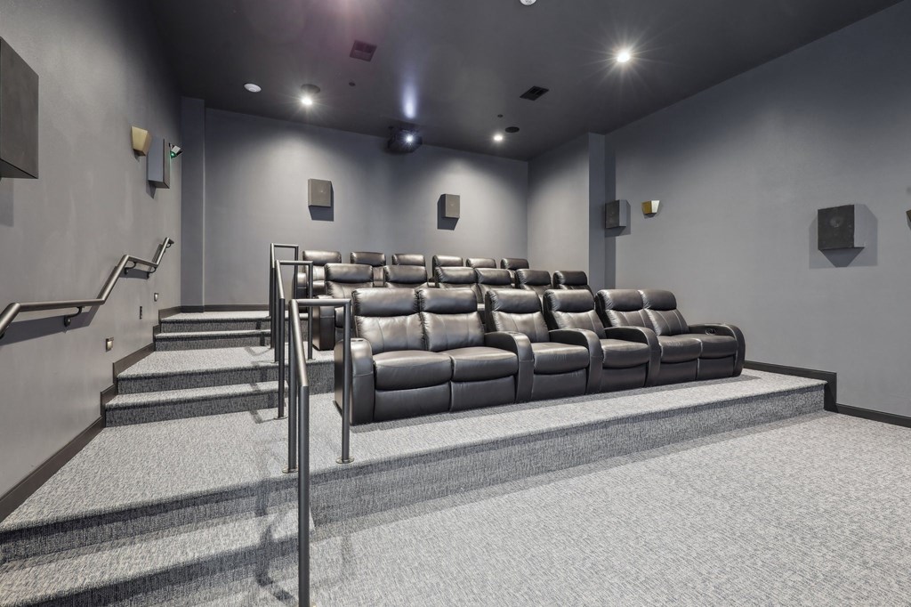 A row of black leather seats in a dimly lit room.