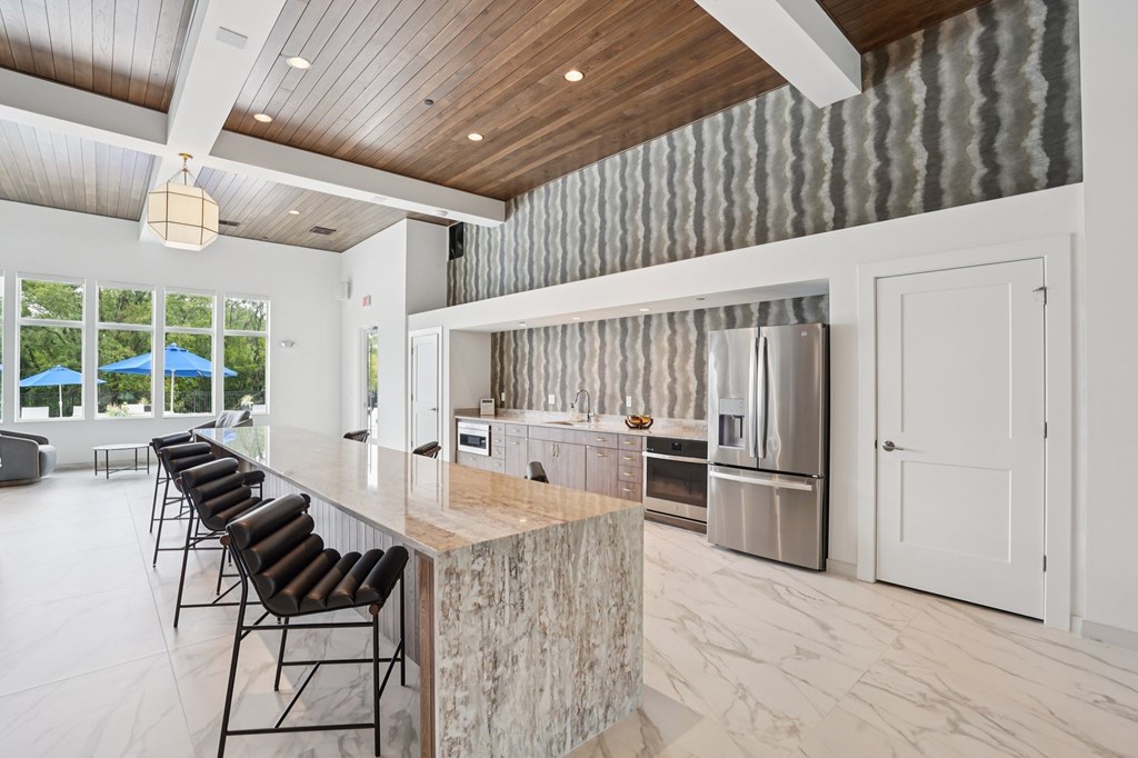 A modern kitchen with a bar area and a dining table.