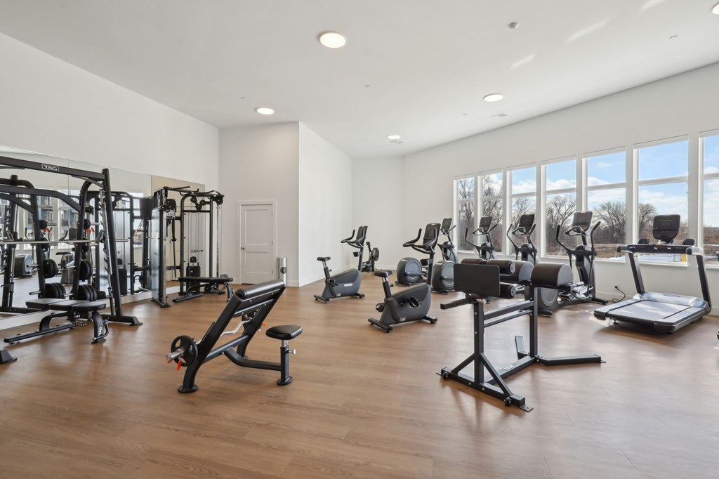A spacious gym with a variety of equipment including treadmills, weights, and exercise machines.