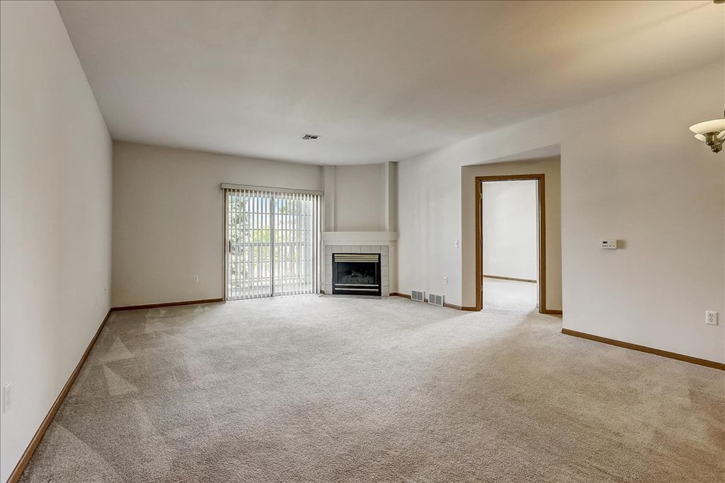 an empty living room with a fireplace and a doorway