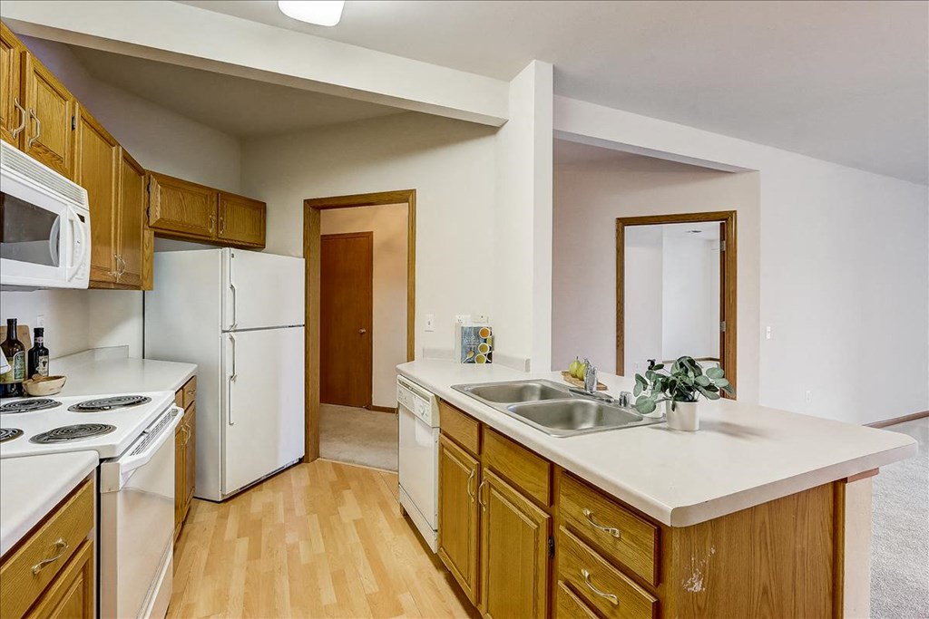 a kitchen with white appliances and wooden cabinets