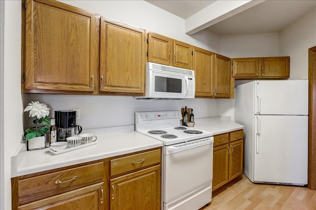 a kitchen with white appliances and wooden cabinets