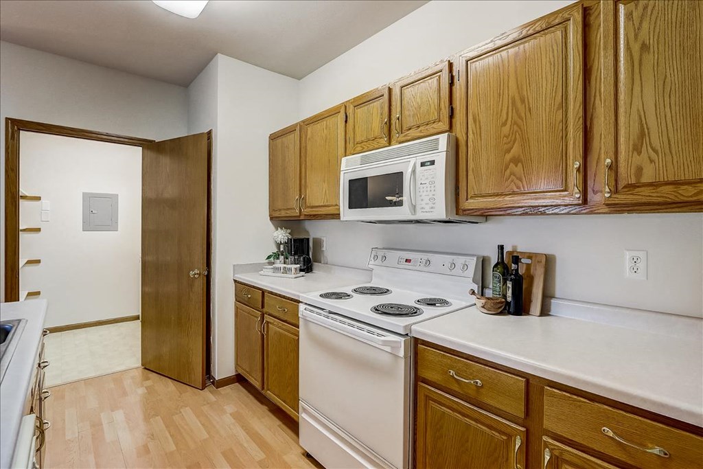 a kitchen with white appliances and wooden cabinets