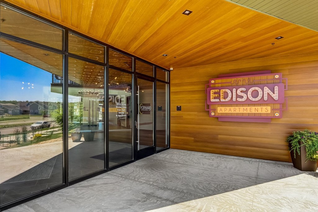 the entrance to a building with glass doors and a sign that reads