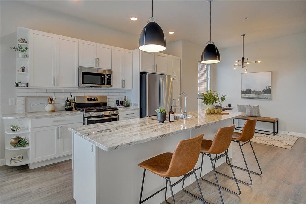 a kitchen with a large island with four chairs
