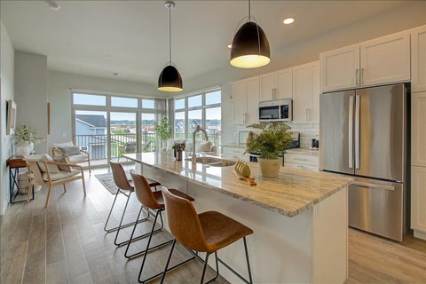 a kitchen with a large island and a stainless steel refrigerator