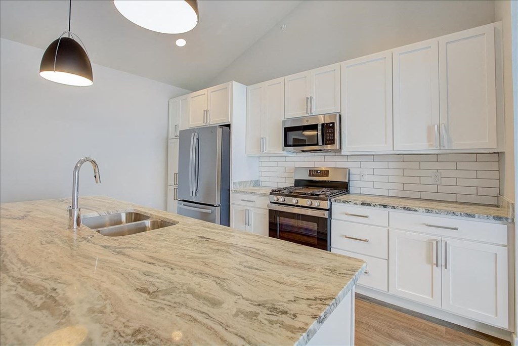 a kitchen with a marble counter top and a sink