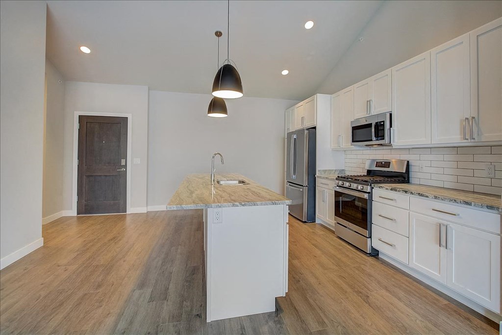a kitchen with an island and a stove and a refrigerator