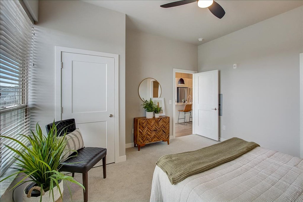 a bedroom with a bed and a chair and a window