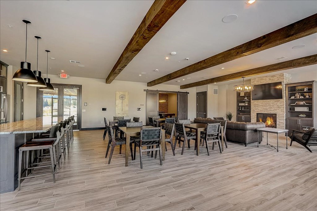 a large living room with tables and chairs and a fireplace